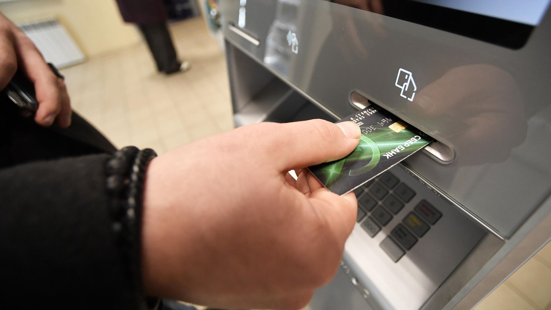 Клиент Sber у банкомата