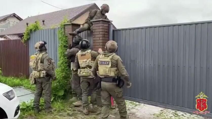 Сотрудники правоохранительных органов во время оперативно-следственных мероприятий по делу об организации незаконной миграции в одном из вузов Ленинградской области. Кадр видео