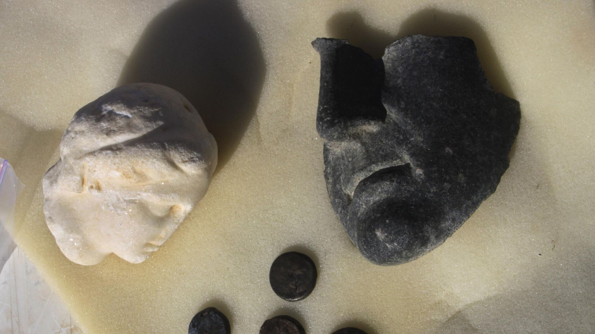 Алебастровая голова статуи царицы Клеопатры, часть маски, предположительно принадлежавшей Марку Антонию, и монеты с изображением Клеопатры, выставленные в храме Тапосирис Магна, который был построен во времена правления царя Птолемея II в Александрии, Египет