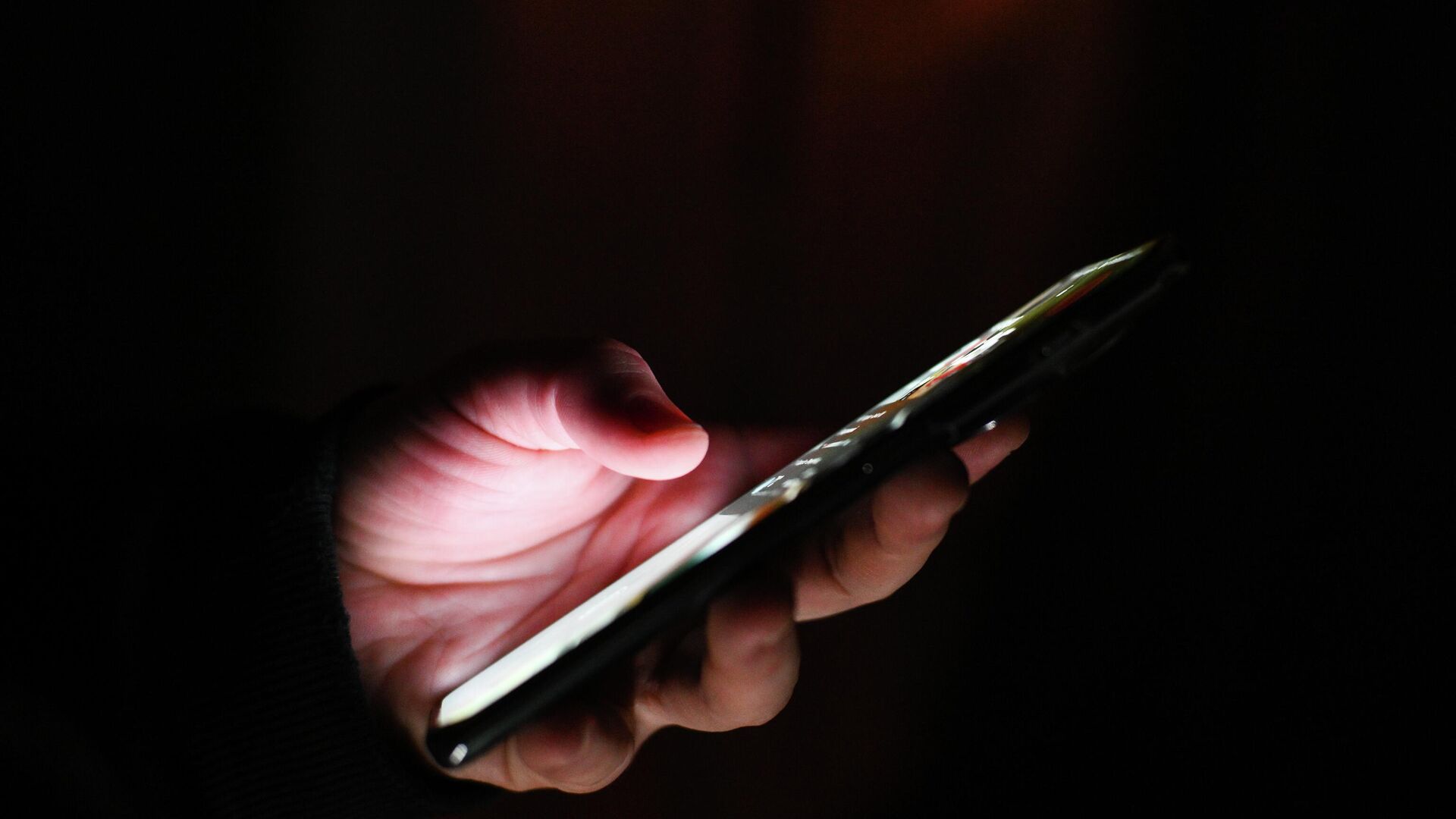 Мужчина держит в руках мобильный телефон